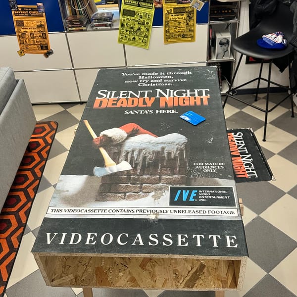 Image of an over-sized VHS tape of Silent Night, Deadly night on saw horses in an office as it is being built